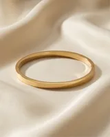 Esclava rígida de acero con baño de oro, de diseño minimalista y superficie lisa.