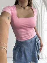 Remera negra ajustada al cuerpo, con escote cuadrado y mangas cortas.