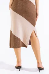 Vestido midi de punto sin mangas, con diseño a rayas diagonales en tonos marrón y tostado con hilo metalizado. Cuenta con escote bote, corte recto y abertura lateral en el dobladillo.