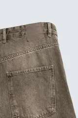 Jeans de corte holgado y amplio en toda la pierna, tiro medio. Tejido rígido con estampado a cuadros con efecto lavado. Cuenta con cinco bolsillos y cierre frontal con cremallera y botón.