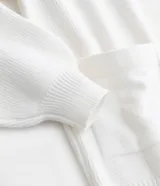 Cardigan abierto de punto color blanco, con mangas largas abullonadas, bolsillos delanteros y diseño alargado.