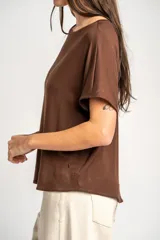 Remera de viscosa marrón, de corte oversize, con mangas cortas y cuello redondo.