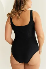 Malla entera negra con textura y nudo en el escote.