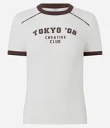 Remera de manga corta color marfil con detalles marrones en contraste en el cuello, costuras de los hombros y puños. Presenta una estampa frontal con la inscripción "TOKYO '08 CREATIVE CLUB" en color marrón, corte ajustado al cuerpo y diseño de estilo urbano.