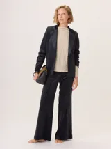 Pantalón de pierna ancha estilo Oxford, color negro, confeccionado en simil terciopelo con brillo sutil. Presenta bolsillos laterales.