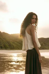 Top de gasa color menta con cuello halter y lazada posterior. Presenta detalles de bordados calados a tono y un bajo con terminación en volante.