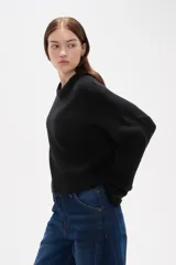 Sweater de tejido de punto color negro, con cuello redondo a la base, mangas largas y diseño holgado.