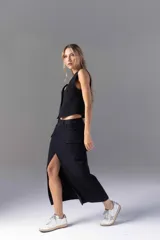 Falda midi negra con tajo lateral, bolsillos cargo y presillas para cinturón.