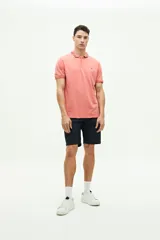 Polo de piqué color salmón, de corte regular, manga corta y logo estampado en el pecho. Confeccionada en algodón y spandex.