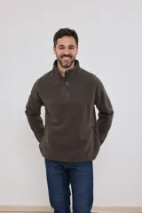 Sweater de polar marrón con cuello alto y cierre parcial con cremallera. Tiene un bolsillo con cierre en el pecho y dos bolsillos laterales con cierre.