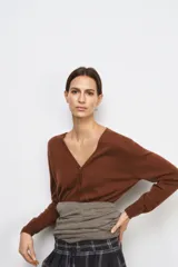 Chaqueta tipo cárdigan de lana, color beige, con escote en pico, manga larga y cierre frontal con botones.