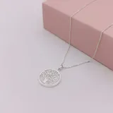 Conjunto de collar y caravanas de plata con dije de nácar con diseño de árbol de la vida.