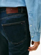 Jeans Tommy Hilfiger modelo Denton de corte recto, con diseño clásico de cinco bolsillos, cierre de botón y cremallera, confeccionado en denim azul oscuro.