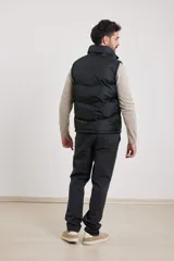 Chaleco verde militar con cierre frontal, cuello alto y dos bolsillos externos con cierre.