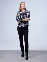 Blusa de gasa estampada con flores en tonos negro, gris y blanco, marca Zac & Rachel. Cuello a la base y abertura central con botones. Delantera con detalle fruncido.