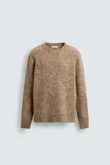 Jersey de punto con textura, confeccionado en una mezcla de lana y fibra de alpaca. Presenta un corte regular fit, cuello redondo y manga larga con acabados en rib.