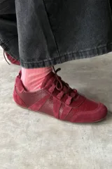 Championes estilo urbano color bordó, con diseño de paneles en gamuza y textura efecto reptil, pasadores finos y suela plana.