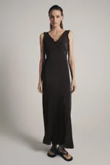 Vestido largo de viscosa en color negro, con escote redondo y tirantes anchos con detalle de volados. Presenta bordados florales a tono en la parte superior y bajo con terminación evasé.