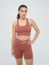 Top deportivo Umbro color negro con diseño de espalda nadadora y banda elástica en la base para mayor soporte.