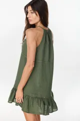Vestido corto verde militar de lino, con escote halter fruncido en el cuello y detalle de volados en el ruedo.