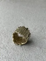 Anillo de diseño escultural y texturado, con acabado rugoso que simula una superficie montañosa o corteza.