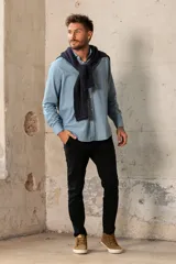 Camisa celeste de manga larga con cuello clásico y cierre frontal con botones.