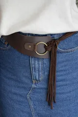 Faja de diseño estructurado confeccionada en una combinación de napa lisa y gamuza negra. Presenta un cierre frontal con argolla metálica plateada y detalles de flecos laterales.