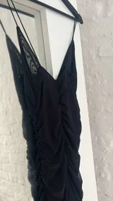 Vestido corto negro de microtul con breteles finos y escote en V.