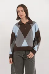 Sweater de tejido de punto con diseño de rombos en tonos marrón, celeste y gris. Presenta cuello polo con cierre frontal de tres botones, mangas largas y puños acanalados.