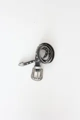 Cinto negro de cuero con tachas plateadas y hebilla metálica con diseño floral.