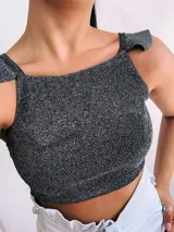 Crop top negro con textura brillante, breteles anchos con volados y espalda descubierta que se ata con lazos.