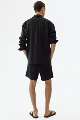 Short de lino y viscosa color negro, de corte relajado, con cintura elástica y cordón de ajuste.