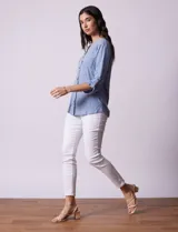 Blusa Ninety color beige con textura, cuello base con escote en V y abertura central con botones. Tiene un bolsillo en el pecho y mangas 3/4 regulables con presilla y botón.