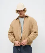 Campera bomber masculina de gamuza sintética color bordó, con cuello camisero, cierre frontal metálico, bolsillos laterales invisibles y rib elástico en puños y ruedo.