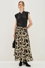 Falda midi con estampado geométrico en tonos negro y dorado metalizado. Presenta una cintura elástica fruncida y un corte fluido con caída suave.