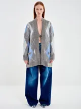 Saco largo de punto con diseño de rombos en tonos gris, azul y blanco. Presenta un calce amplio, silueta relajada y cierre frontal con un único botón. Confeccionado en una mezcla de fibras que incluye lana y poliamida con acabado texturizado.