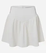 Short pollera corto de malla waffle color blanco, con cintura ancha en V y cierre de cremallera en la espalda. Presenta rayas contrastantes en los laterales.