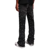 Pantalón de jean negro de corte flare, con lavado acid wash y apliques de strass en toda la prenda.