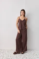 Pantalón wide leg de tiro medio y calce amplio, color marrón, con pinzas delanteras, cierre frontal y bolsillos laterales funcionales.