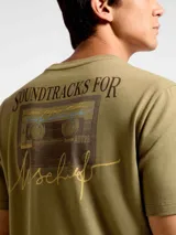 Camiseta blanca de algodón con cuello redondo y mangas cortas. Estampa rectangular con borde negro que contiene la frase "NATURAL ATMOSPHERE" en letras mayúsculas y una imagen de montañas y mar.