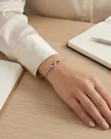 Pulsera de plata con dije central en forma de símbolo de infinito, decorado con circonias engastadas en toda su superficie y en parte de la cadena.