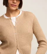 Cardigan corto color tostado de punto con textura acanalada, cuello redondo, manga larga y cierre frontal con botones.