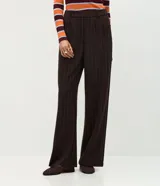 Pantalón de corte recto confeccionado en punto roma, con diseño de raya de tiza. Presenta cintura estructurada con trabillas para cinturón y bolsillos laterales.