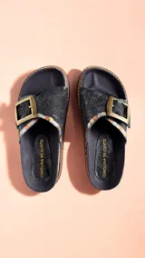 Sandalias de cuero color negro con detalles pintados a mano, tira ancha con hebilla metálica grande y suela de goma.