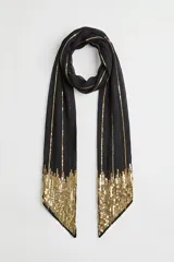 Pashmina de viscosa negra con detalles de líneas doradas de hilo metalizado y bordado de lentejuelas doradas en los extremos.