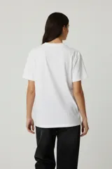 Remera de algodón de manga corta y cuello redondo, con diseño holgado y estampado gráfico frontal con motivos florales y tipografía vintage.