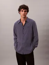 Camisa de manga larga Calvin Klein con estampado de rayas verticales finas, cuello camisero y cierre frontal con botones.
