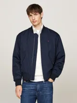 Campera bomber azul marino Tommy Hilfiger, con cuello, puños y bajo de punto canalé. Cierre frontal con cremallera, dos bolsillos laterales con botón a presión y logo bordado en el pecho.