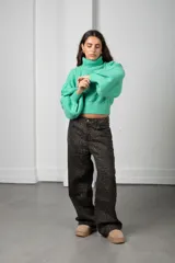 Polera de tejido de punto color verde menta, con cuello alto, mangas largas abullonadas y puños y cintura acanalados.
