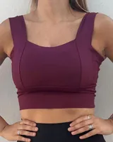 Top deportivo color bordó con escote cuadrado y breteles anchos. Presenta costuras verticales que realzan la forma del busto y una banda inferior ancha para mayor sujeción.